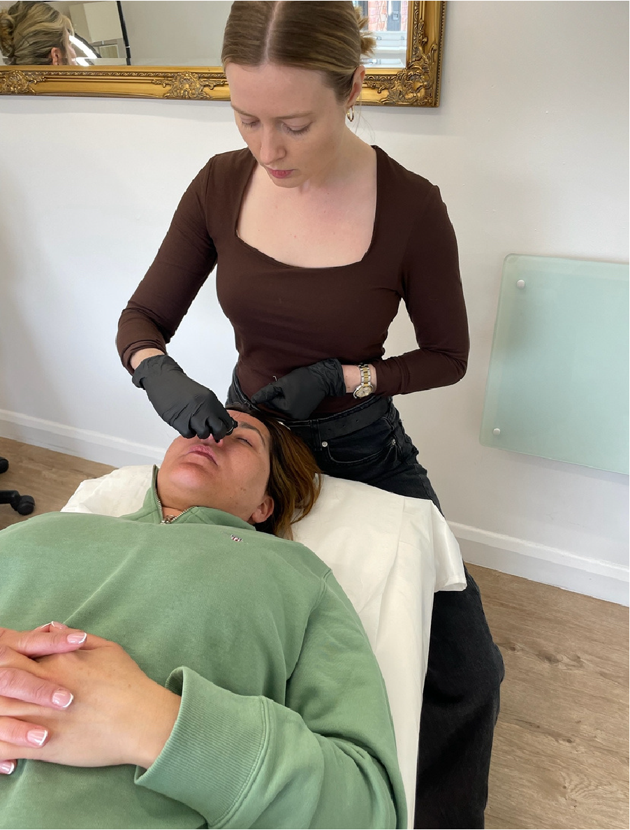 Hayley from Inkourage performing a combination brow treatment on a client